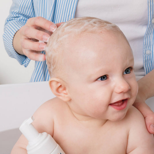 Mousse de shampoing sur les premiers cheveux d’un bébé